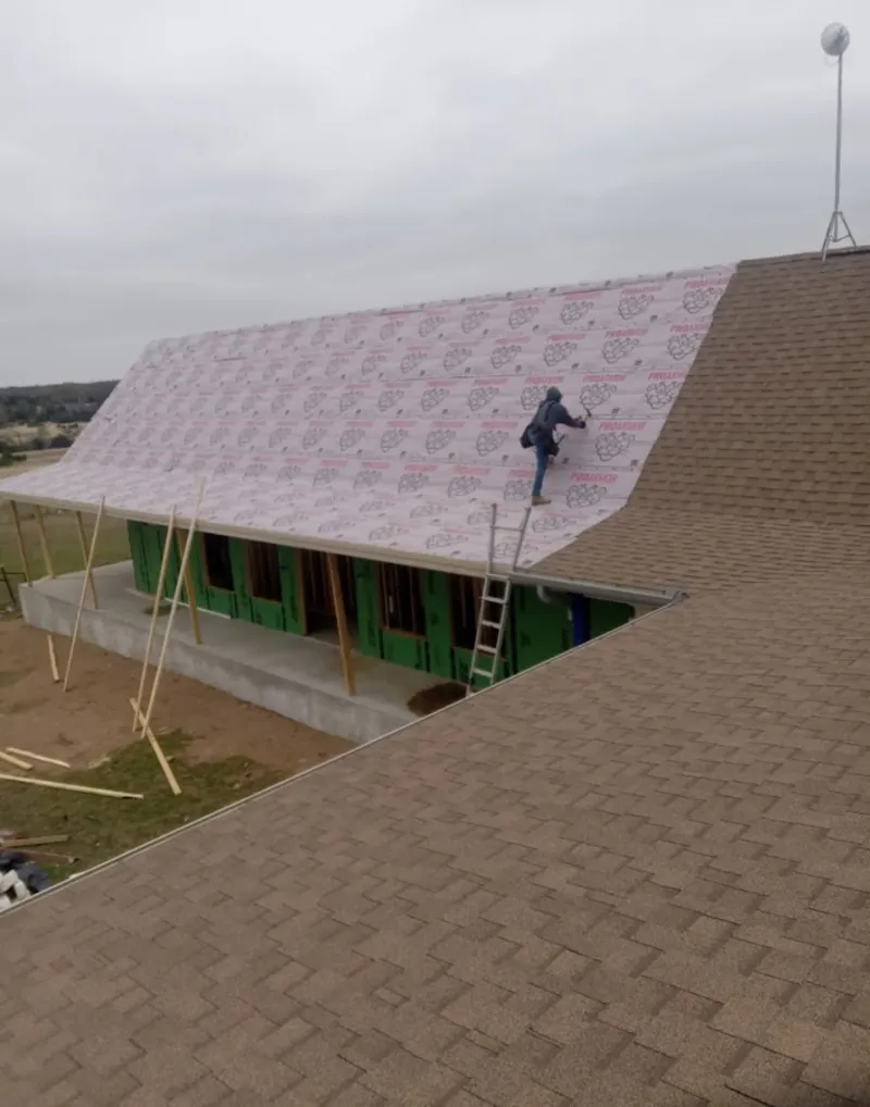 Worker preparing underlayment for a metal roof installation in Townsend